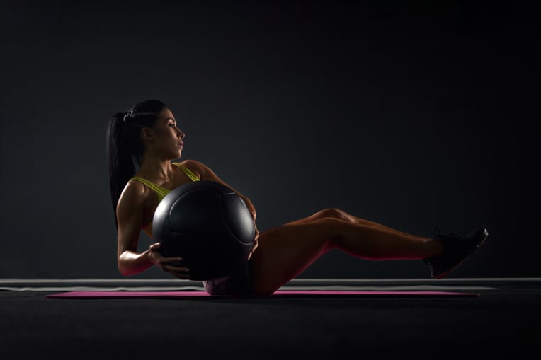 sportswoman-training-abs-with-ball-in-gym-2025-03-24-11-07-04-utc